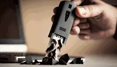 Изображение человека, держащего USB-накопитель, на фоне шредера